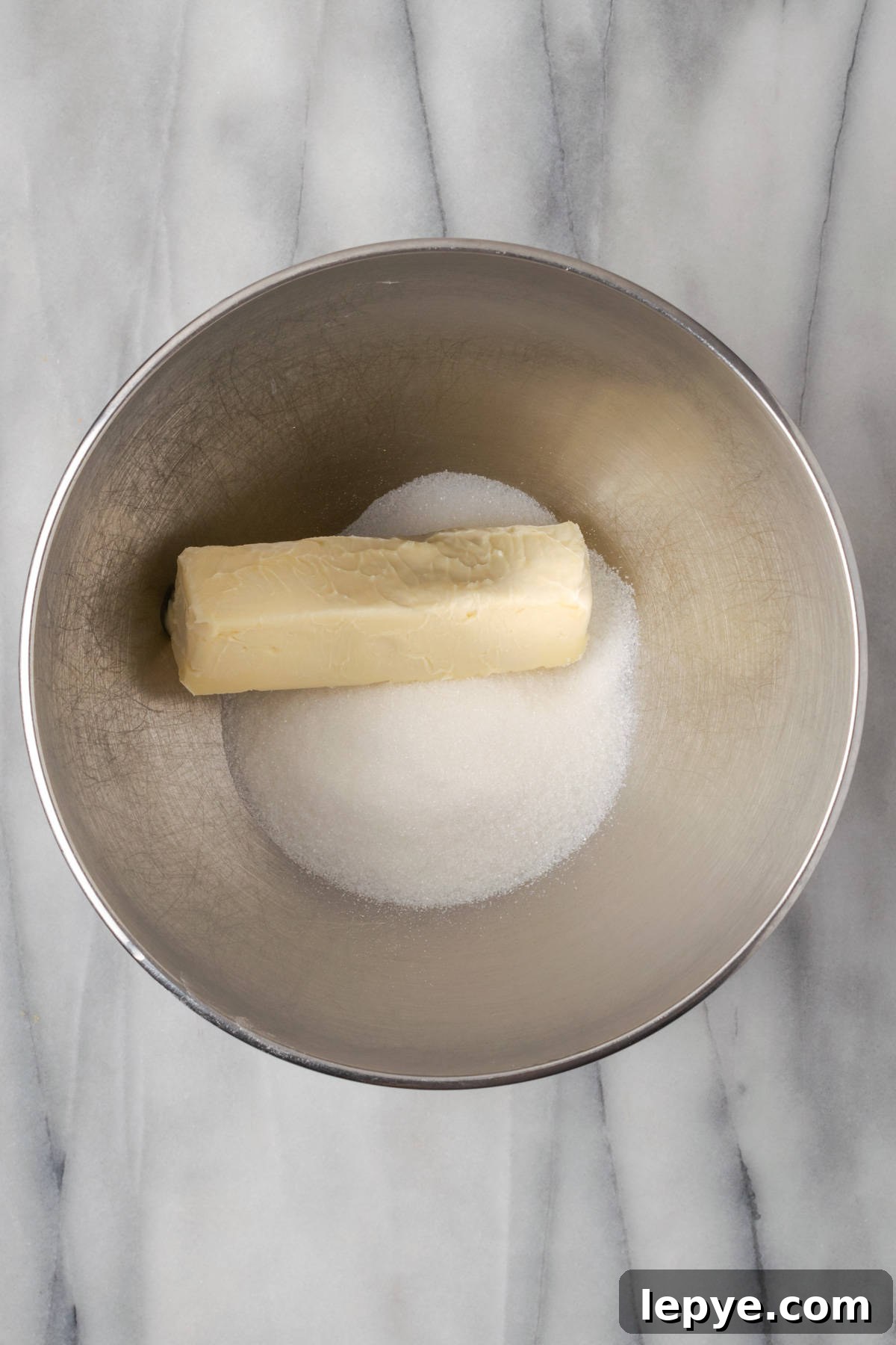 Butter and sugar combined in the bowl of an electric mixer.
