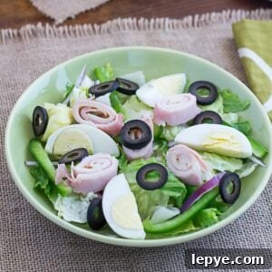 Classic Chef's Salad Recipe: How to Make It at Home 8 A chef's salad served in a green bowl.