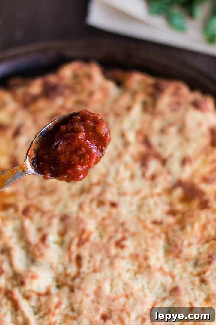 Adding sauce to keto pizza crust