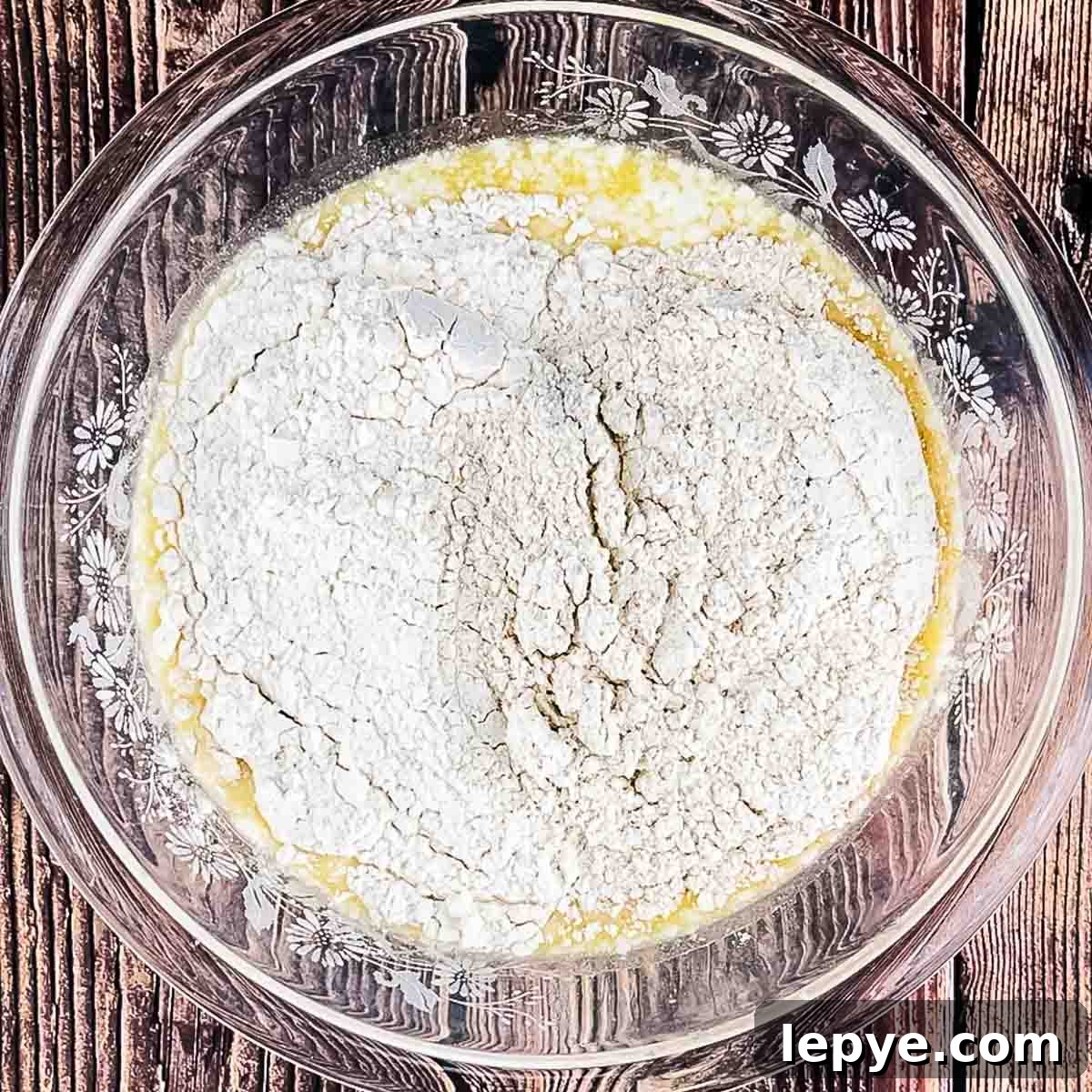 The ingredients for the waffle batter in a glass mixing bowl.