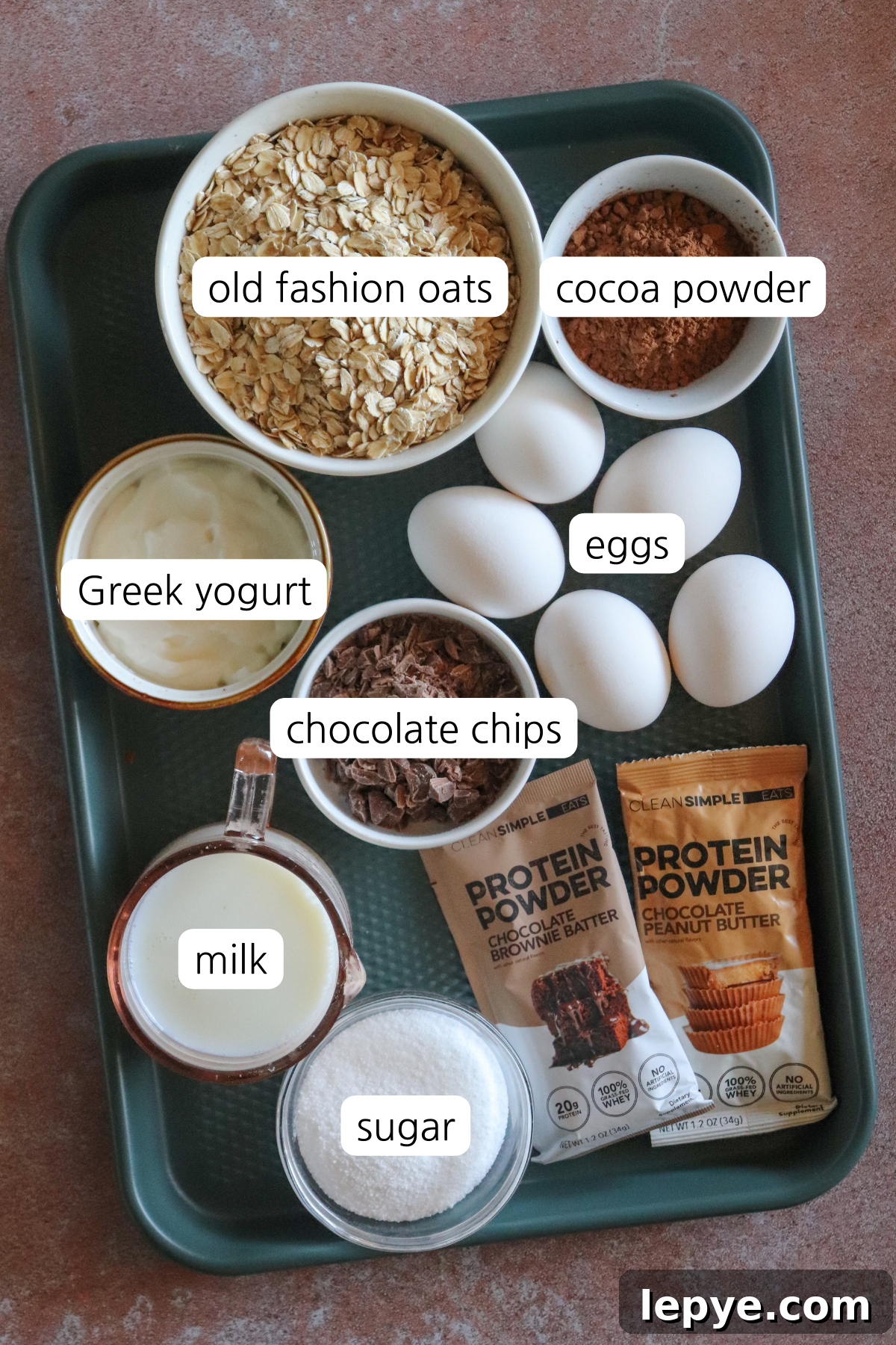 Chocolate baked oats showing small bowls labeled with ingredients on a small baking sheet.