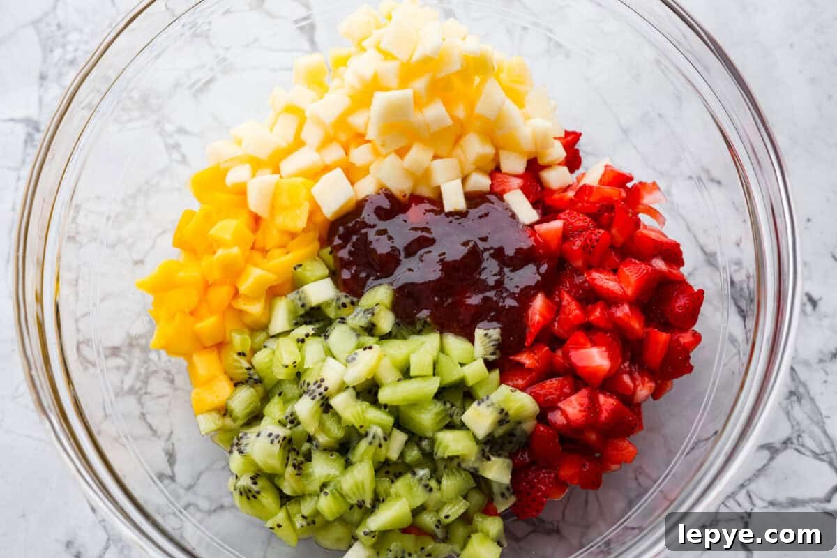 Vibrant fruit salsa is a fresh, juicy twist on your favorite snack! Sweet berries, tropical mango, and a splash of lime always steal the spotlight! Especially when served with crispy cinnamon chips! Raspberry jam added to the bowl of diced fruit.