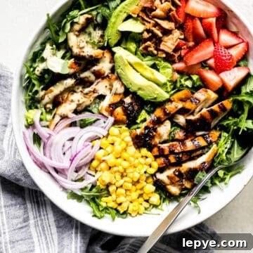 honey mustard chicken salad with avocado, onions, and corn in a large bowl