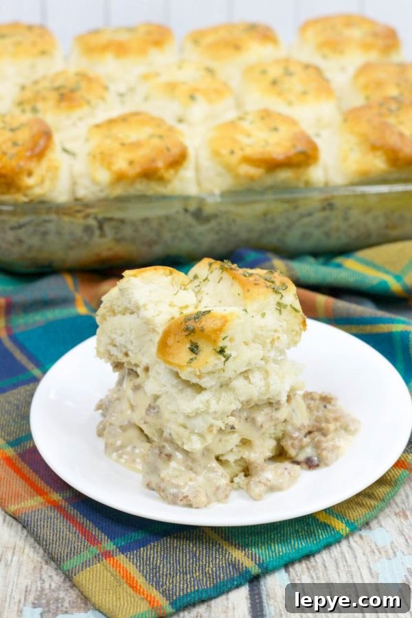 a closeup of biscuits and gravy casserole with the whole casserole in the background.