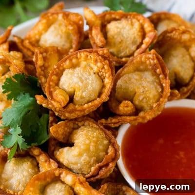 Crispy Fried Wontons: Easy Homemade Recipe for Crispy Bites 2 A plate of fried wonton served with sweet chili sauce.