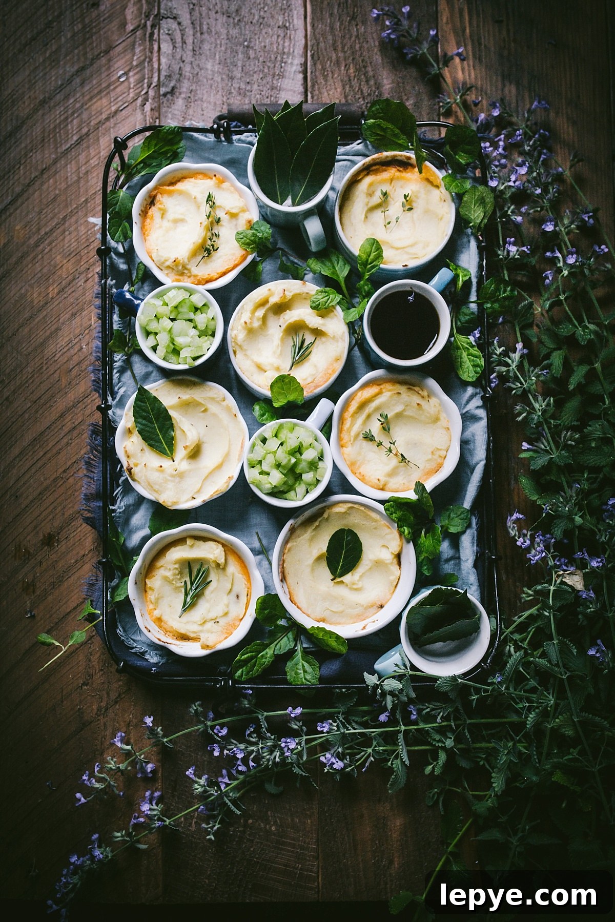 artfully arranged tray of individual servings of cottage pie with swirled golden brown mashed potatoes