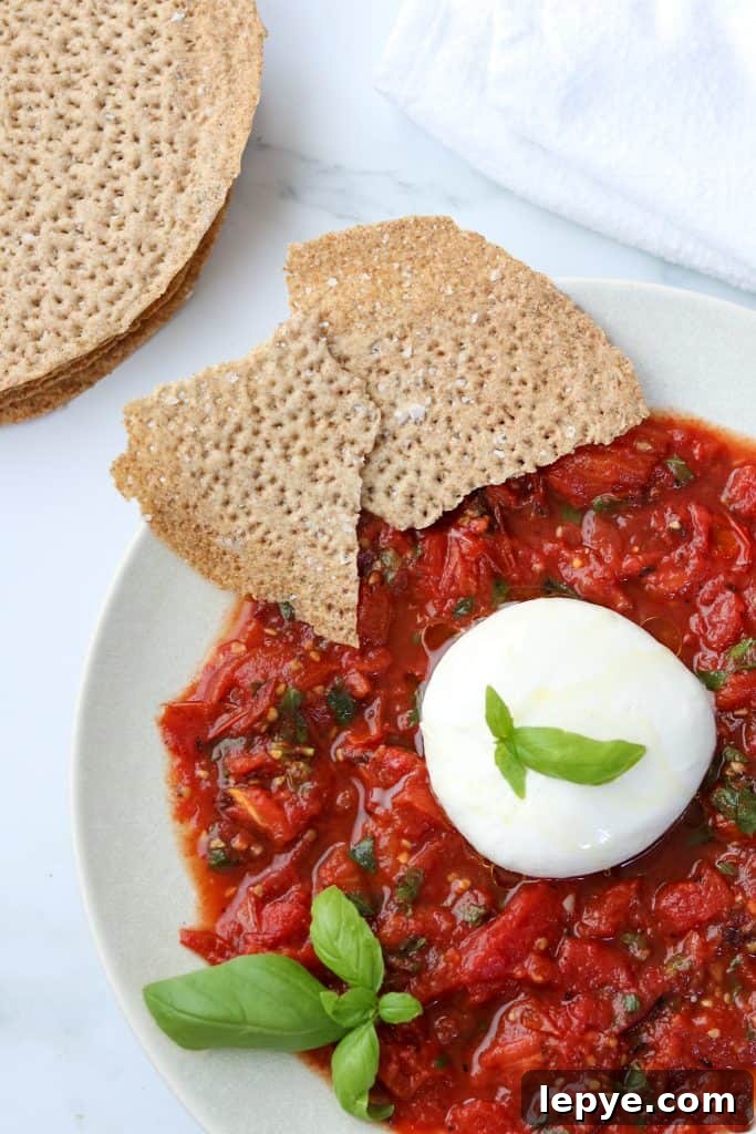Smoky Grilled Tomatoes with Burrata and Crispy Crispbread 2 A plate with grilled tomatoes, basil, burrata and crispbread