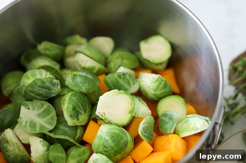 Sheet Pan Chicken with Roasted Butternut Squash 7 A bowl filled with cut Brussels sprouts and Squash.