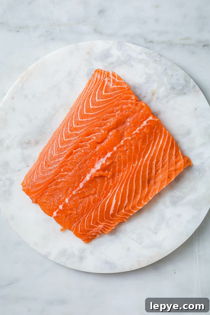 25-Minute Salmon Tikka Recipe: Quick Spiced Fish Tikka 4 A center-cut piece of raw salmon a a marble slab.