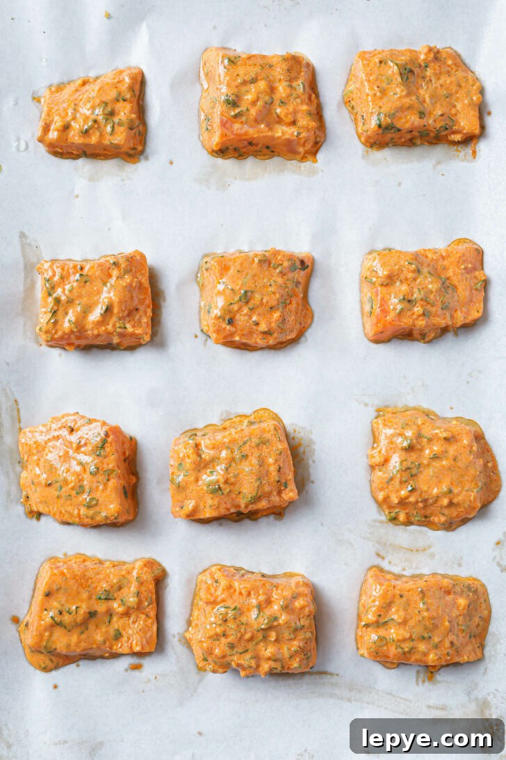 25-Minute Salmon Tikka Recipe: Quick Spiced Fish Tikka 8 A parchment covered sheet pan with marinated Fish Tikka ready to be broiled.