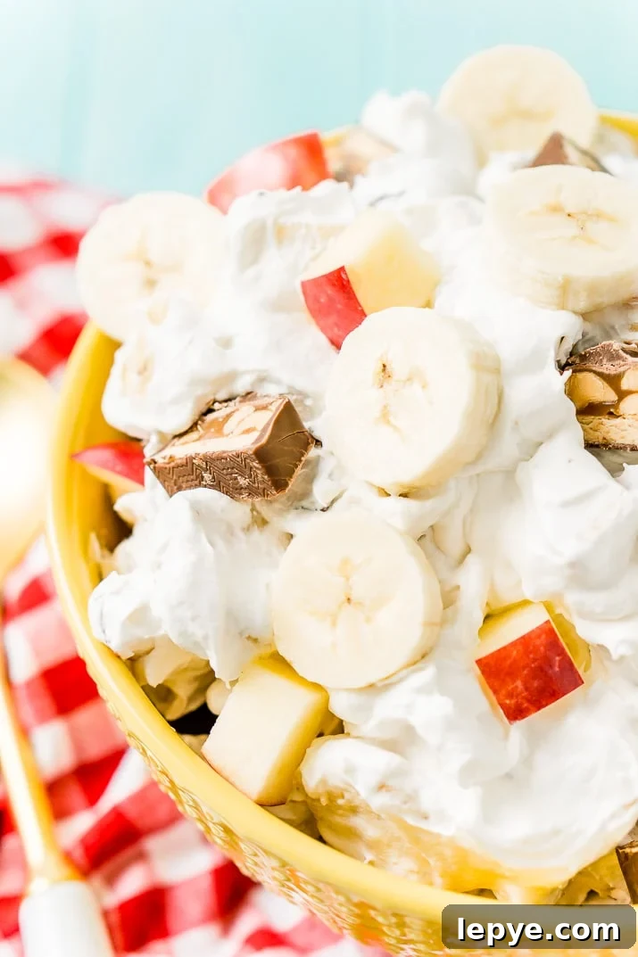 This Snickers Salad is an easy and addictive 4-ingredient no-bake dessert salad made with Snickers, banana, apples, and Cool Whip!