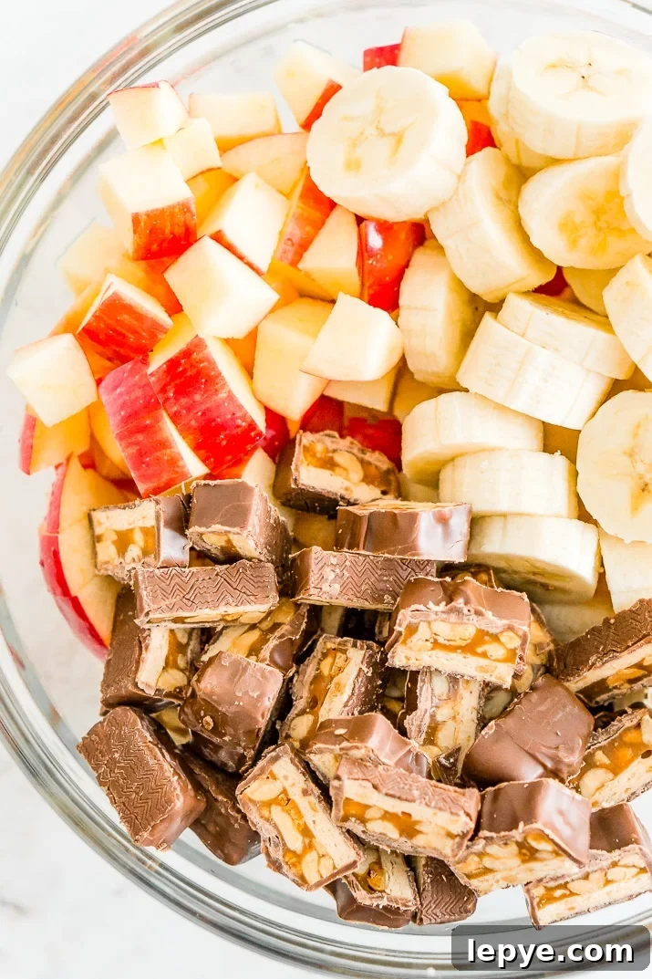 This Snickers Salad is an easy and addictive 4-ingredient no-bake dessert salad made with Snickers, banana, apples, and Cool Whip!