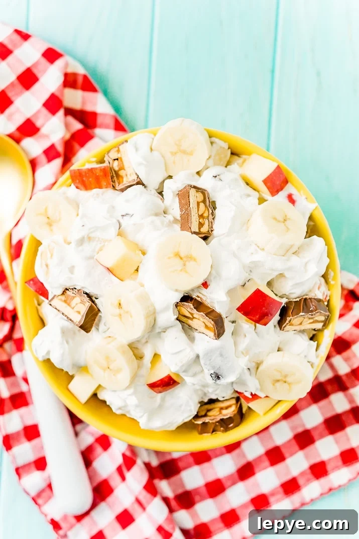This Snickers Salad is an easy and addictive 4-ingredient no-bake dessert salad made with Snickers, banana, apples, and Cool Whip!