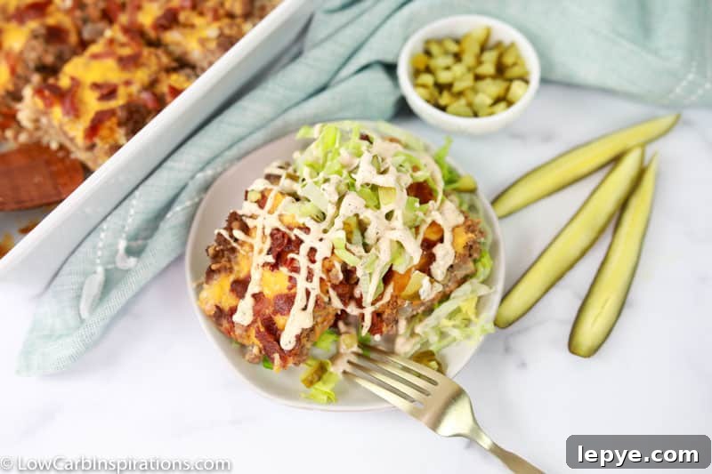overhead photo of keto casserole recipe on a white plate with pickle spears and ground beef casserole in the background