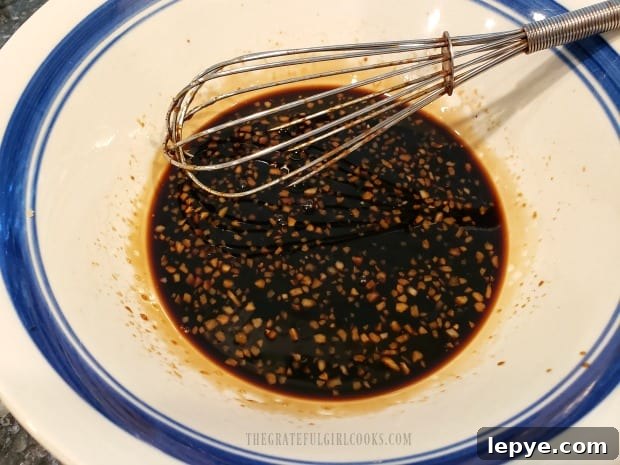 Ingredients for homemade teriyaki marinade are whisked together in a bowl.