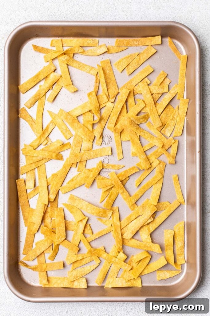 Crispy baked tortilla strips on a baking sheet.