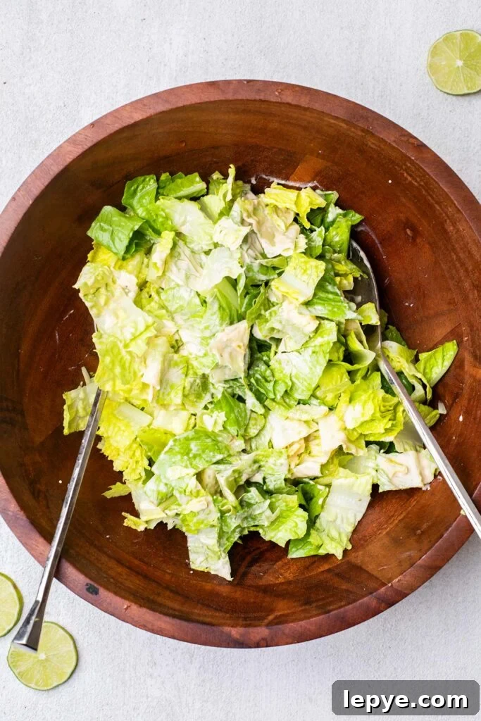 Romaine lettuce chopped in a bowl tossed with a creamy dressing.