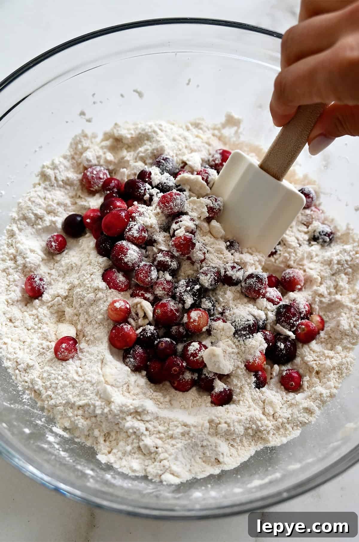 Folding cranberries into a flour and butter mixture.