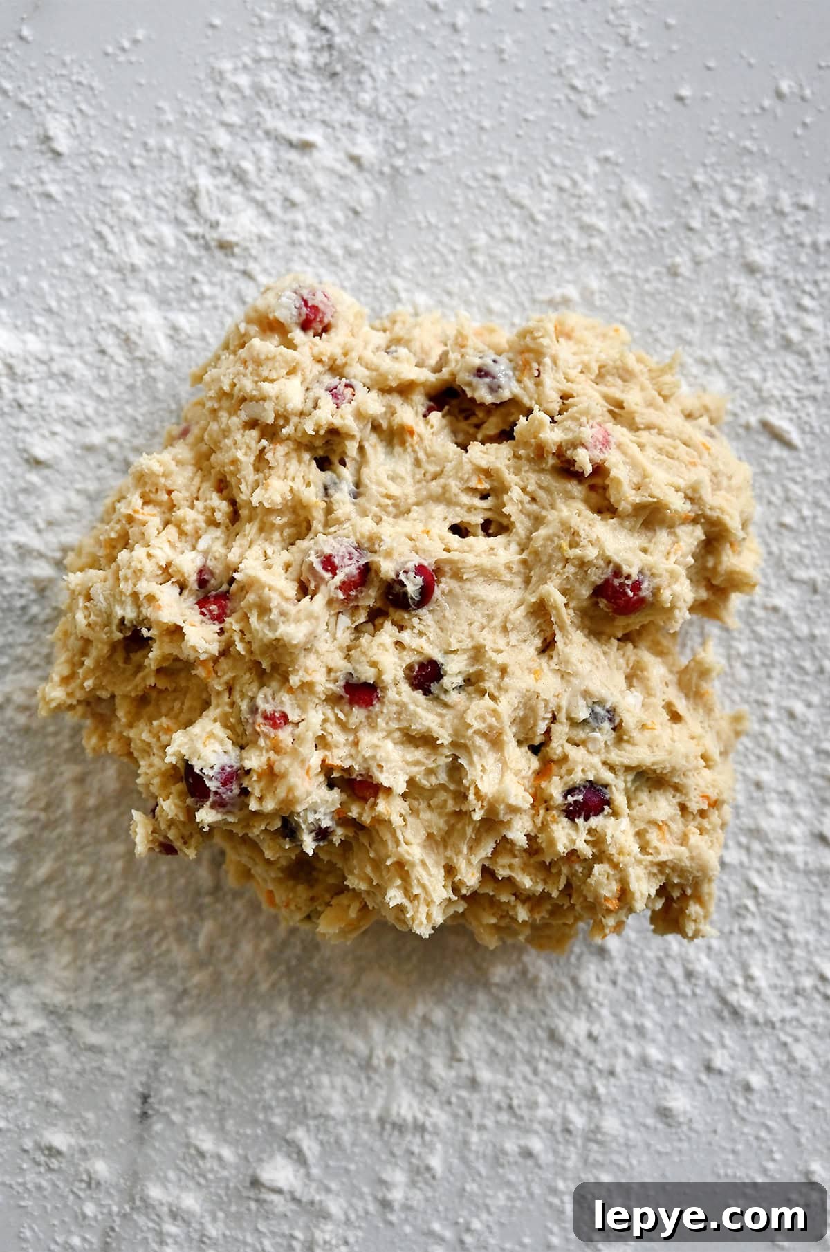 Shaping orange cranberry scone dough on a floured surface.