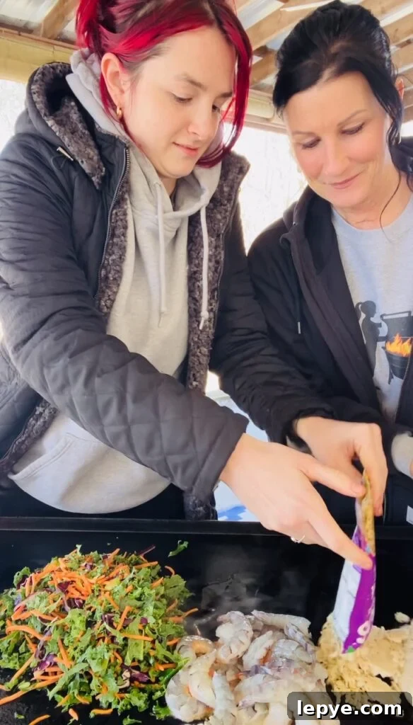 adding veggies shrimp and rice to griddle
