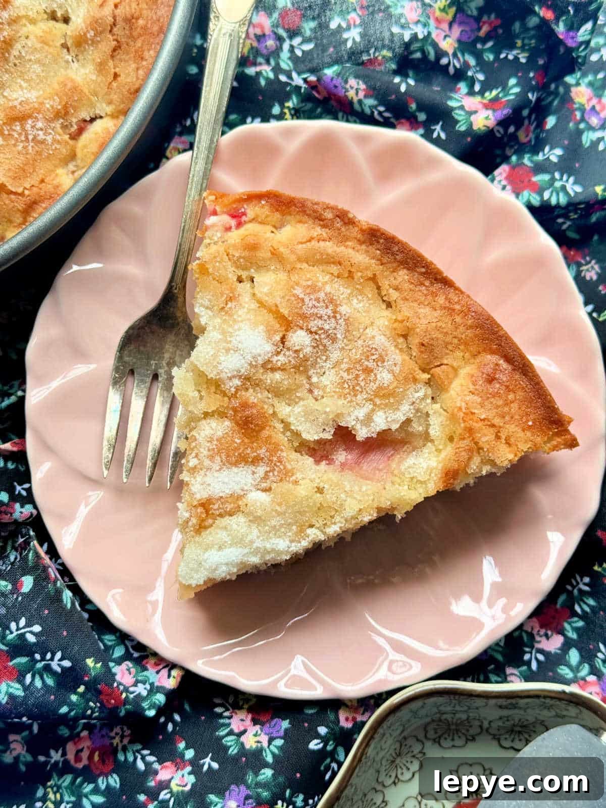 a slice of rhubarb cake on a pink plate