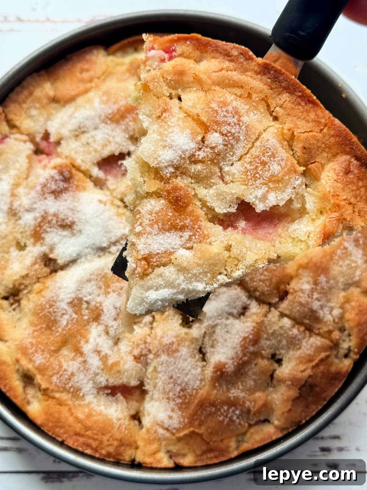 serving a slice of rhubarb cake from the pan
