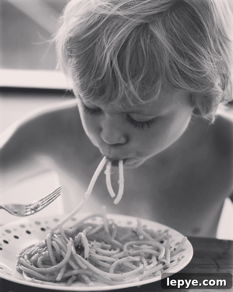 Sunday Story: How Pasta Sparks Simple Kitchen Magic 2 Black and white photo of a child eating pasta.