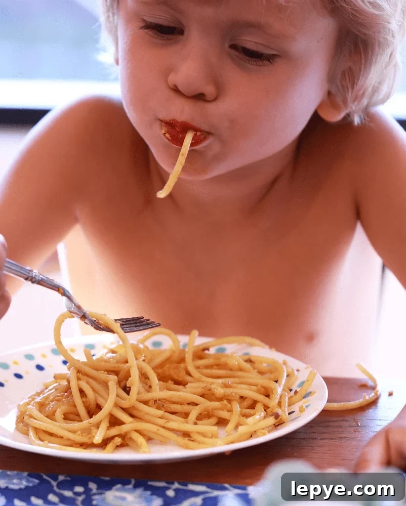 Sunday Story: How Pasta Sparks Simple Kitchen Magic 3 Child eating pasta with a fork.