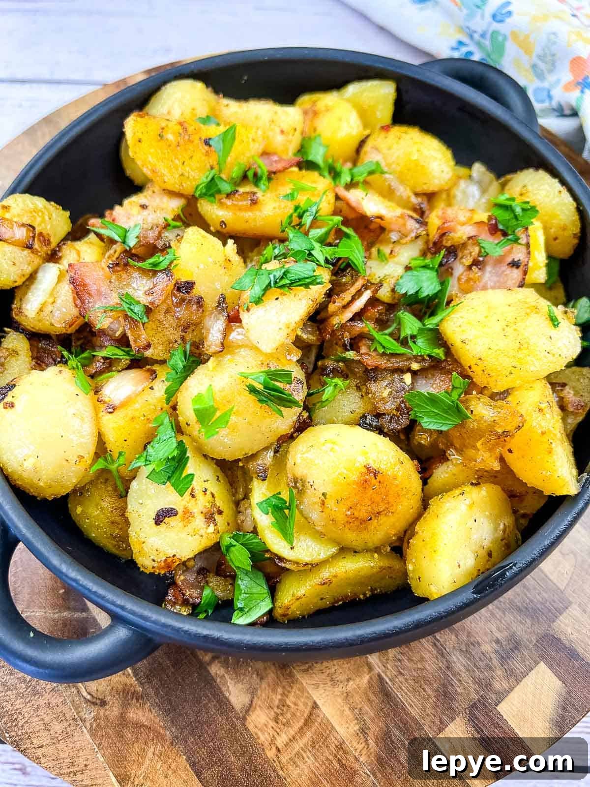 Crispy Blackstone Fried Potatoes: Simple Skillet Recipe 2 blackstone fried potatoes in a black dish on a cutting board