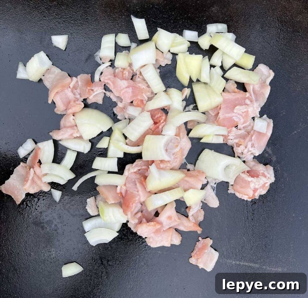 Crispy Blackstone Fried Potatoes: Simple Skillet Recipe 5 onion and bacon frying on the blackstone