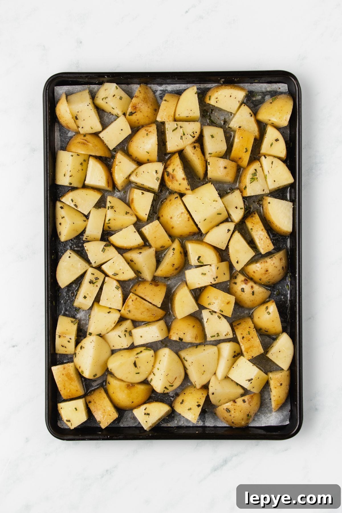 Crispy Oven-Roasted Potatoes with Garlic and Herbs 5 Potatoes cut into pieces, then seasoned, before being baked.