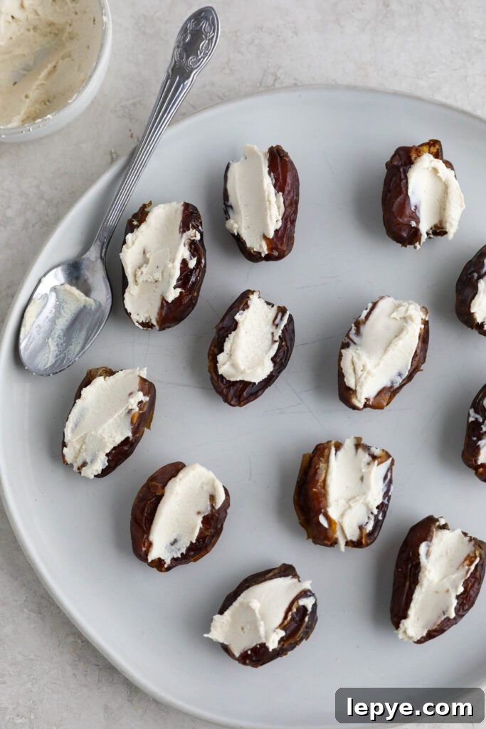 Savory Stuffed Dates: Flavorful Appetizer Recipes for Entertaining 6 Dates with cream cheese in the center on plate with spoon