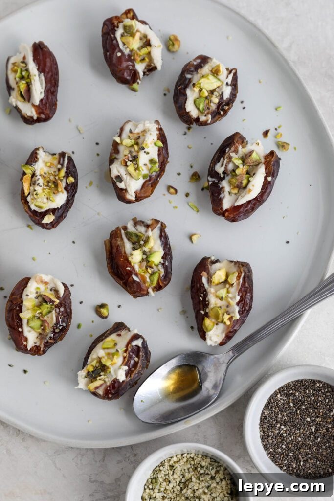Savory Stuffed Dates: Flavorful Appetizer Recipes for Entertaining 8 Dates stuffed with cream cheese and topped with pistachios, hemp hearts, and chia seeds on white plate