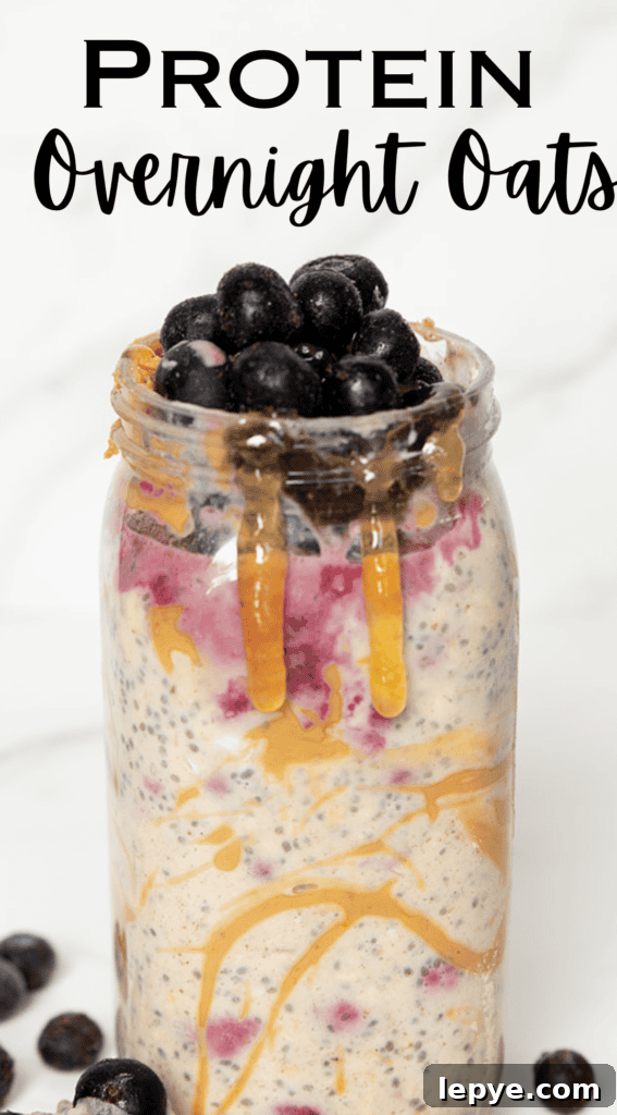 High-Protein Overnight Oats Recipe for Meal Prep and Muscle 10 Protein overnight oats in jar overflowing with blueberries and drizzled honey by FarmhouseHarvest.net copywrite 2024