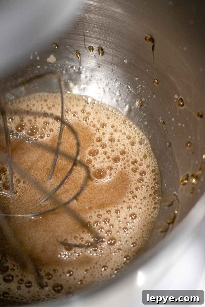 How to Make Homemade Marshmallows from Scratch 6 Mixing sugar water solution into softened gelatin in a stand mixer bowl with balloon whisk.