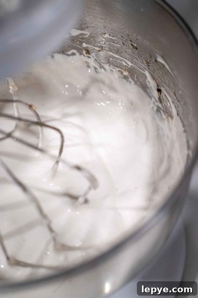 How to Make Homemade Marshmallows from Scratch 9 Adding vanilla to marshmallow fluff in a stand mixer bowl.