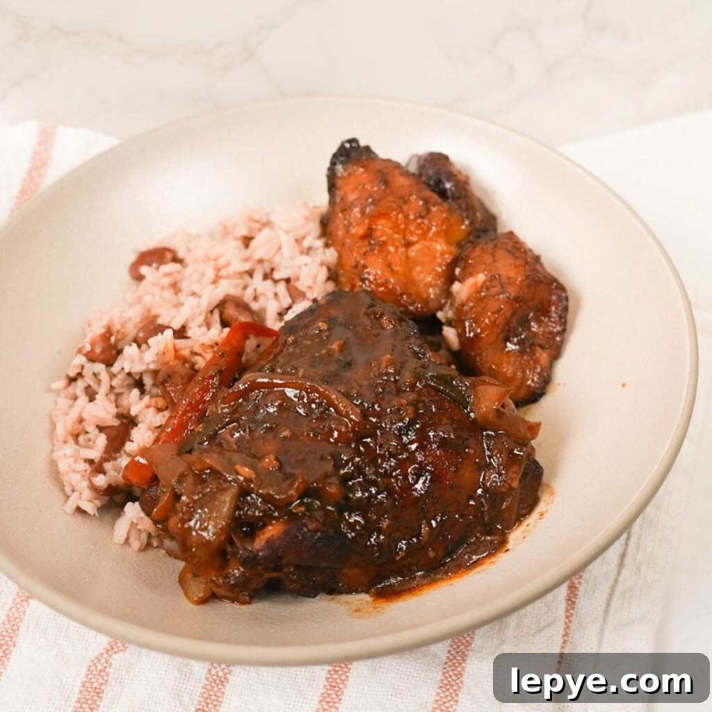 Authentic Jamaican Brown Stew Chicken Recipe 2 Brown stew chicken in thick brown gravy with sliced peppers, thyme, and rice and peas with plantain.