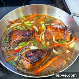 Authentic Jamaican Brown Stew Chicken Recipe 7 Brown stew chicken in a pan waiting to boil.