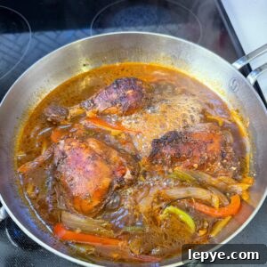 Authentic Jamaican Brown Stew Chicken Recipe 8 Brown stew chicken cooking in a pot.