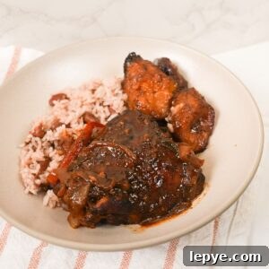 Authentic Jamaican Brown Stew Chicken Recipe 10 Brown stew chicken in thick brown gravy with sliced peppers, thyme, and rice and peas with plantain.