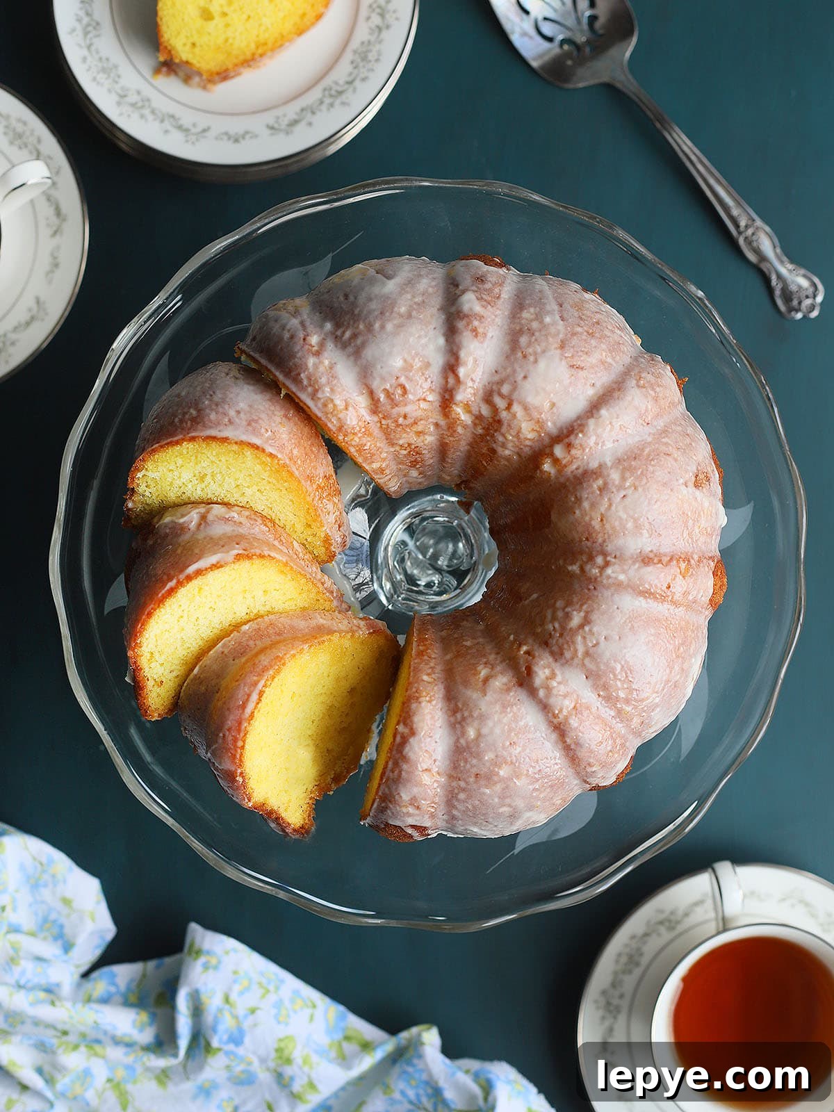 Sliced apricot nectar cake on a clear glass cake pedestal.
