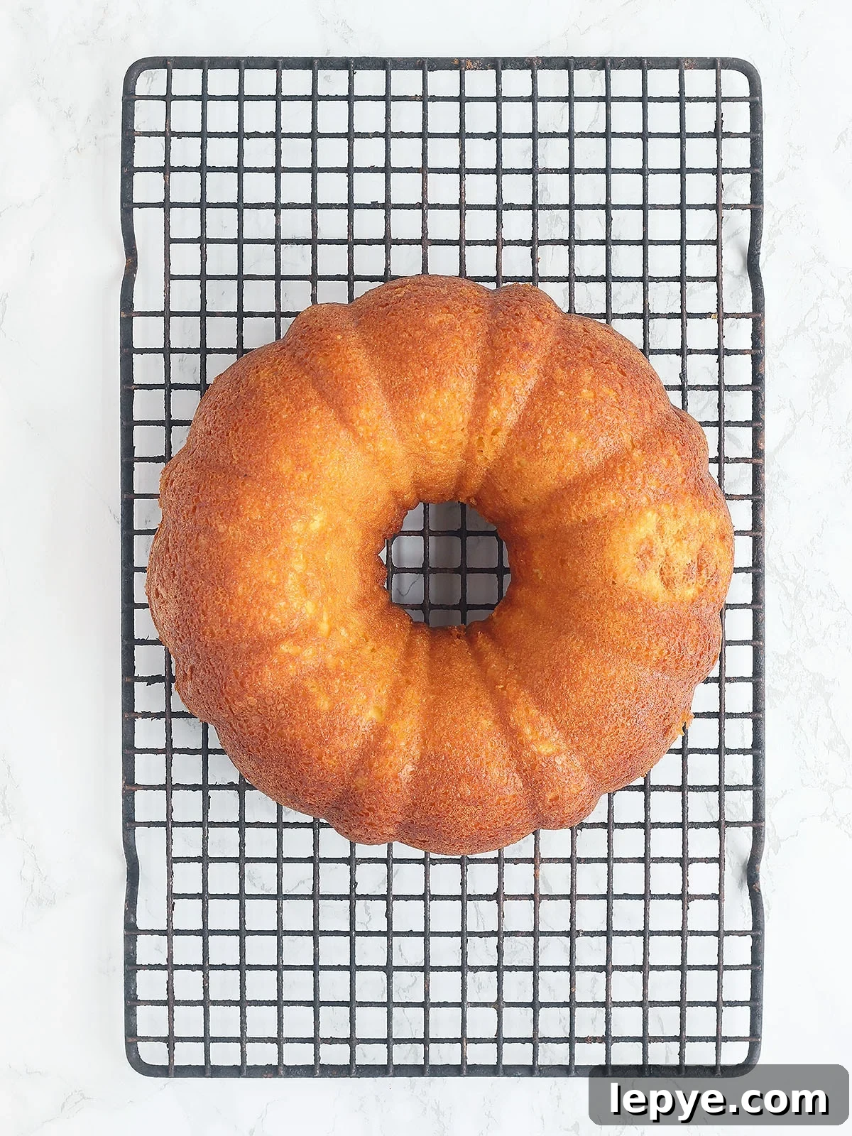 Apricot nectar cake removed from the pan and cooling on a baking rack.
