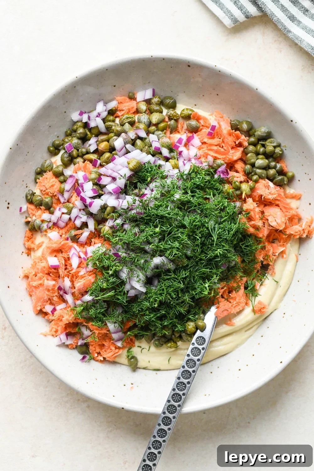 How to make dairy free smoked salmon dip: Smoked salmon, red onion, dill, and capers added to the cashew cream base.