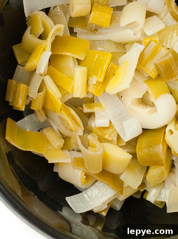 Braised Leeks in Creamy White Wine Sauce 4 cooked leeks in a black bowl.