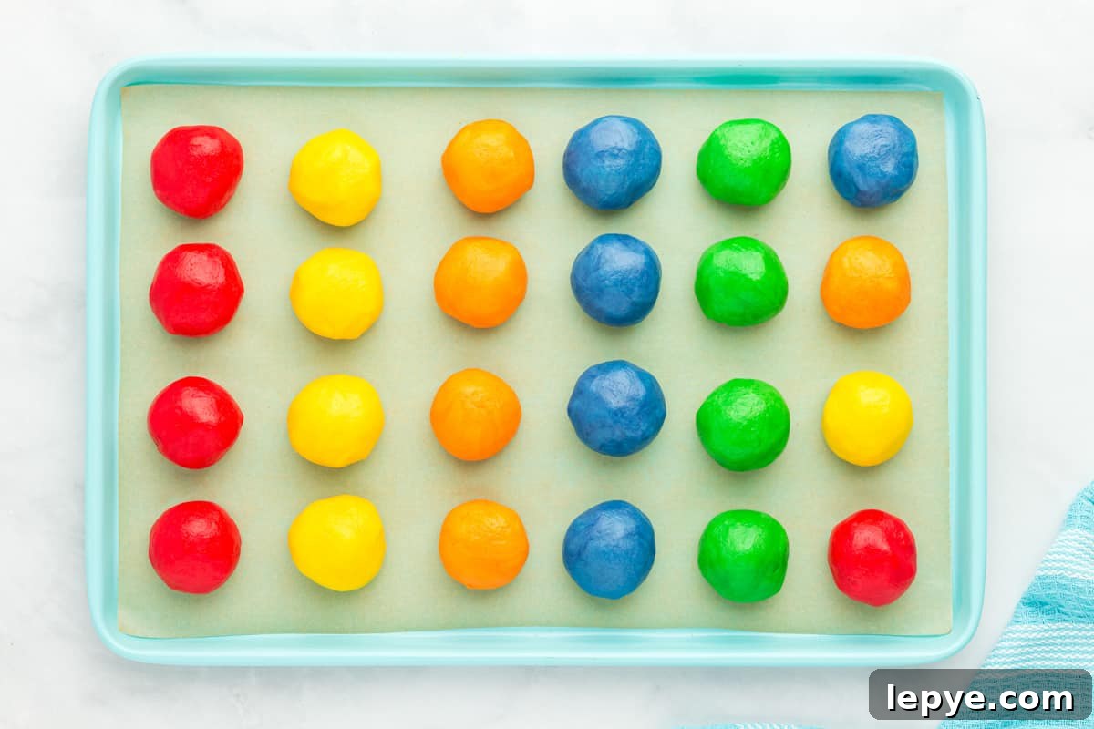 24 jello cookie dough balls on a blue baking sheet.