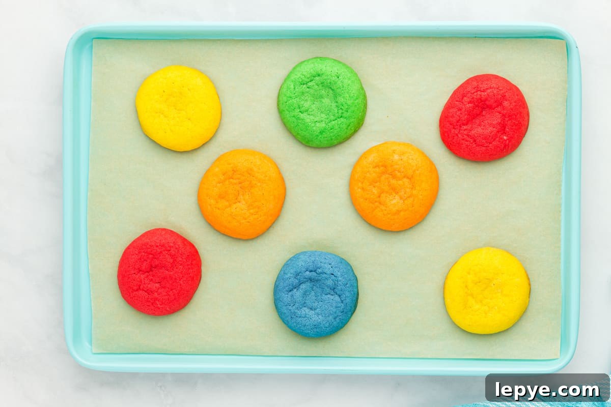 8 baked jello cookies on a blue baking sheet.