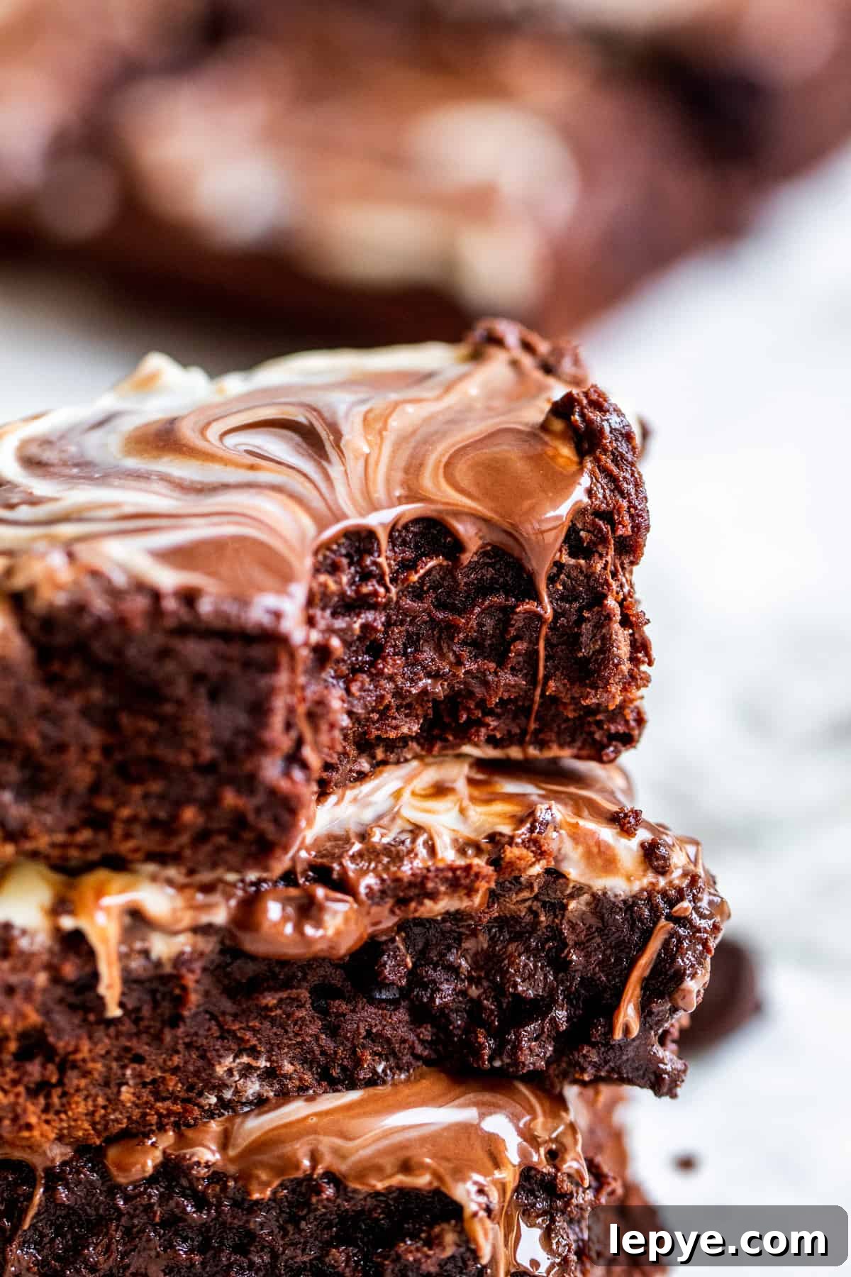 Gooey Chocolate Fudge Brownies with Rich Chocolate Drizzle 8 Stack of brownies with bite out of top one.