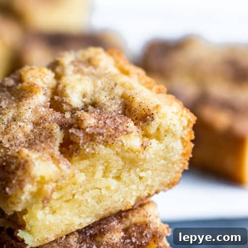 Stack of snickerdoodle blondies on a white counter with some in the background.