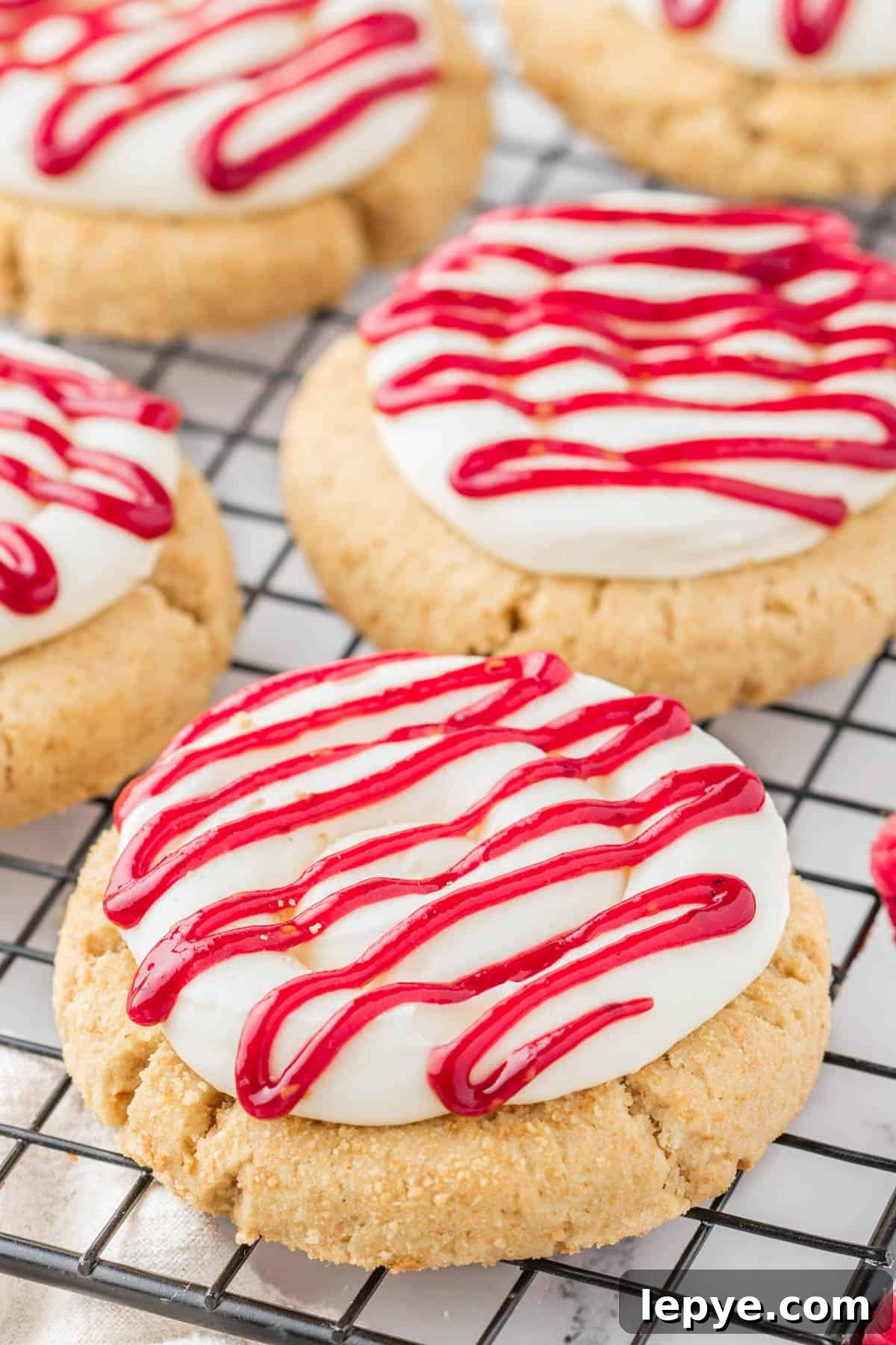 Raspberry Cheesecake Cookie Recipe — Soft, Jam-Filled Treats 6 Graham cracker cookies with cream cheese frosting and raspberry drizzle.
