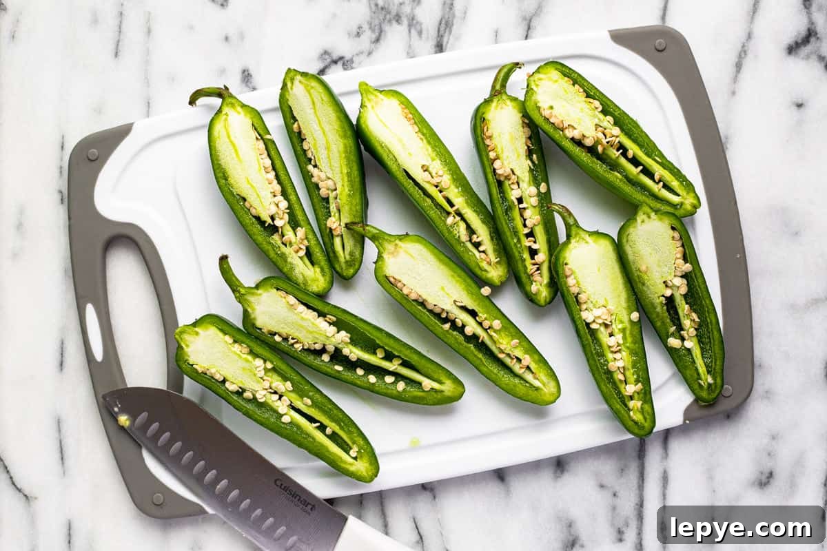 Smoked Jalapeño Poppers Recipe for Perfect Grill Parties 4 White and gray cutting board with sliced jalapenos.